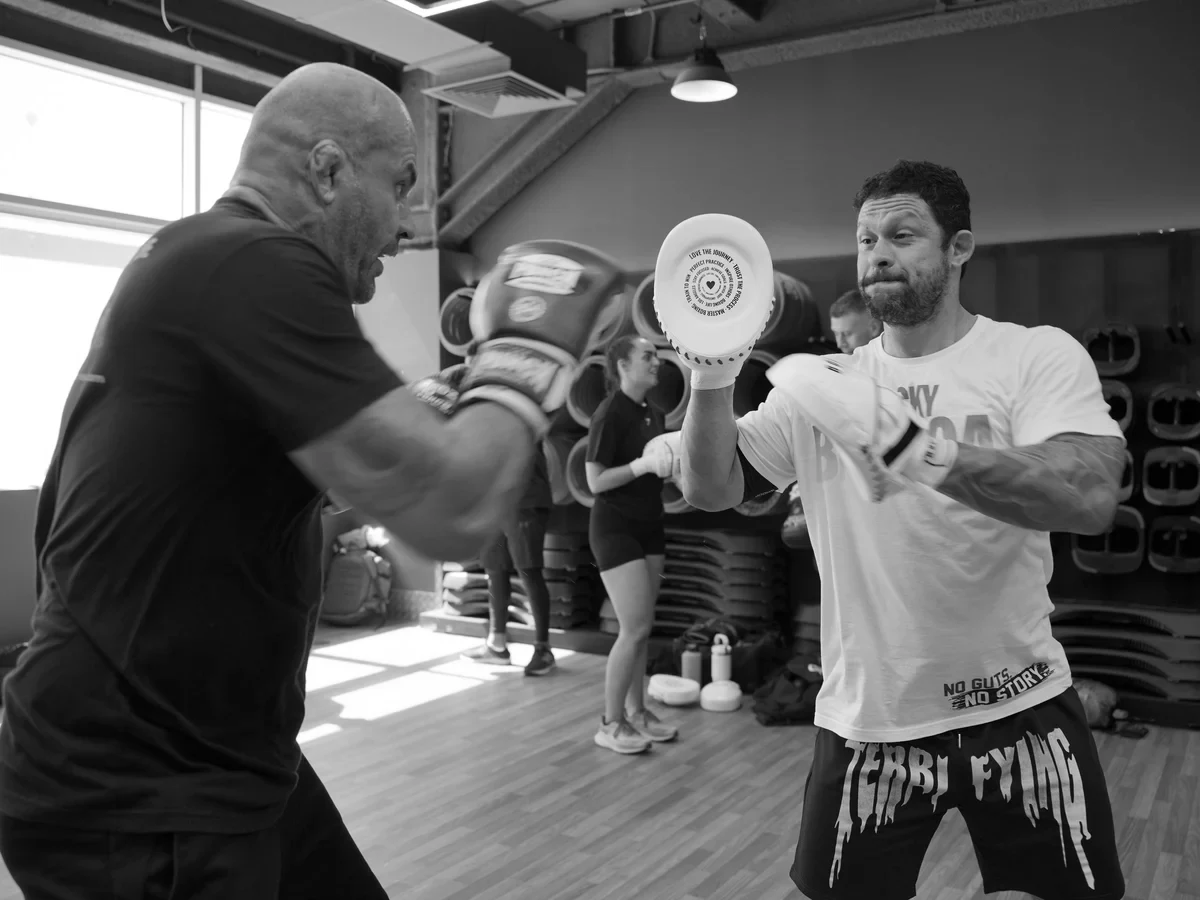 Dois atletas treinando boxe na manopla em uma academia